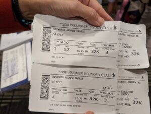 Two Singapore Airlines Premium Economy boarding passes — SQ242 Sydney to Singapore and SQ346 Singapore to Zurich — held in hand at Sydney Airport, January 2026