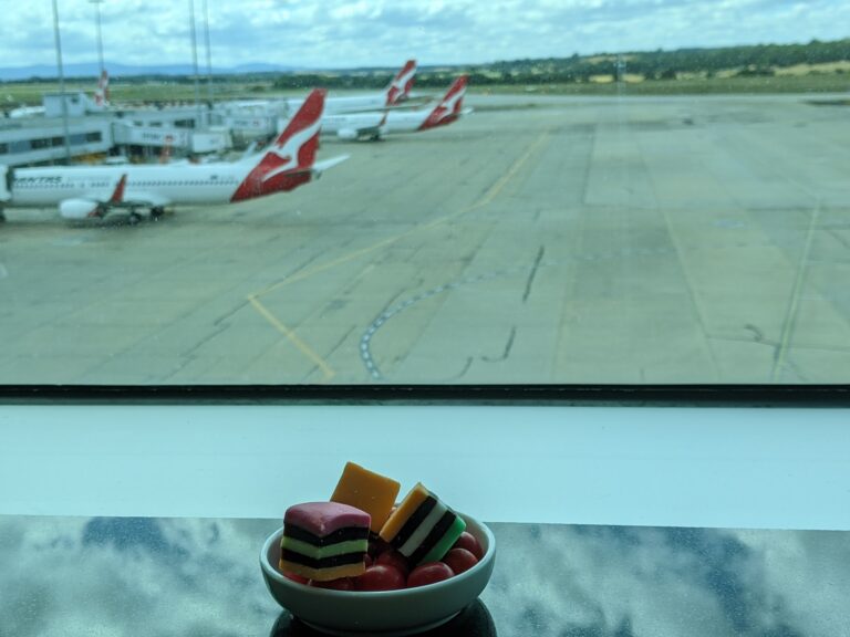 bowl of licorice allsorts at the Qantas Club lounge, Melbourne Airport, with Qantas aircraft on the tarmac