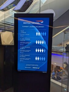 British Airways current lounge occupancy display board at Heathrow Terminal 5, showing First Lounge and Club Lounge North, South and B Gates capacity