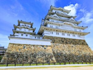 Himeji Castle's white keep against a blue sky, seen from the grounds — Himeji, June 2024