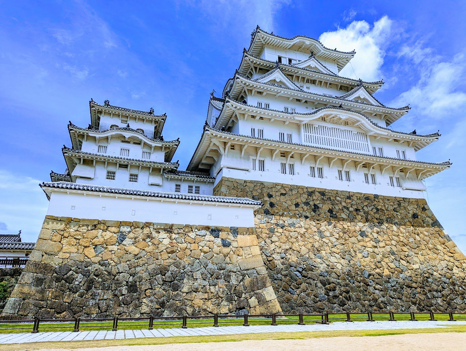 Himeji Castle's white keep against a blue sky, seen from the grounds — Himeji, June 2024