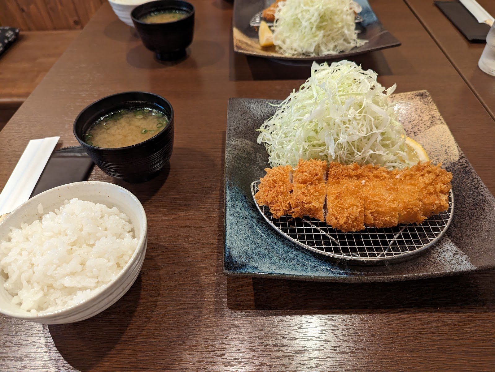 A tonkatsu set meal with pork cutlet, shredded cabbage, rice and miso soup at a restaurant in Osaka — June 2024
