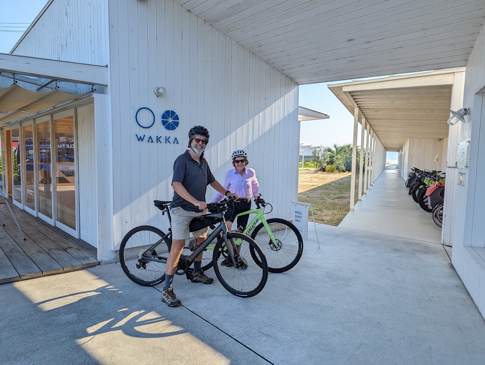 Drew and Julie with their two Specialized e-bikes outside the WAKKA cycling hub on Omishima Island — June 2024