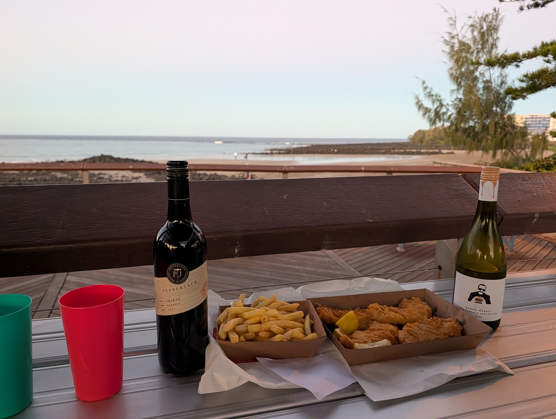 Fish and chips with a bottle of Shiraz and Chardonnay, overlooking Bargara beach at sunset