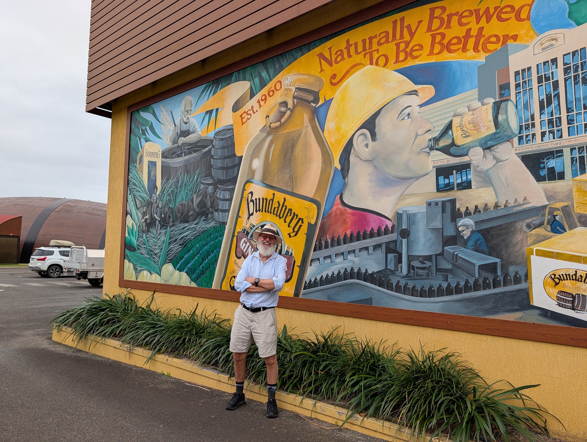Drew standing in front of the Bundaberg Brewed Drinks mural outside the visitor centre