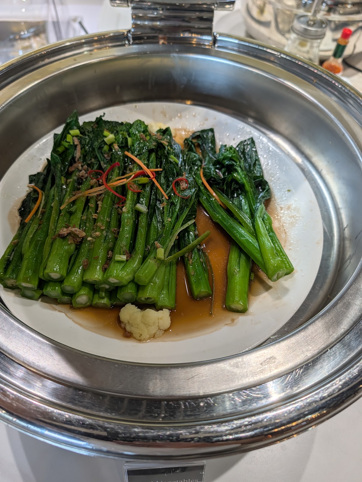 Steamed Asian greens with chilli and fried shallots in a buffet warmer at the Angkor Lounge