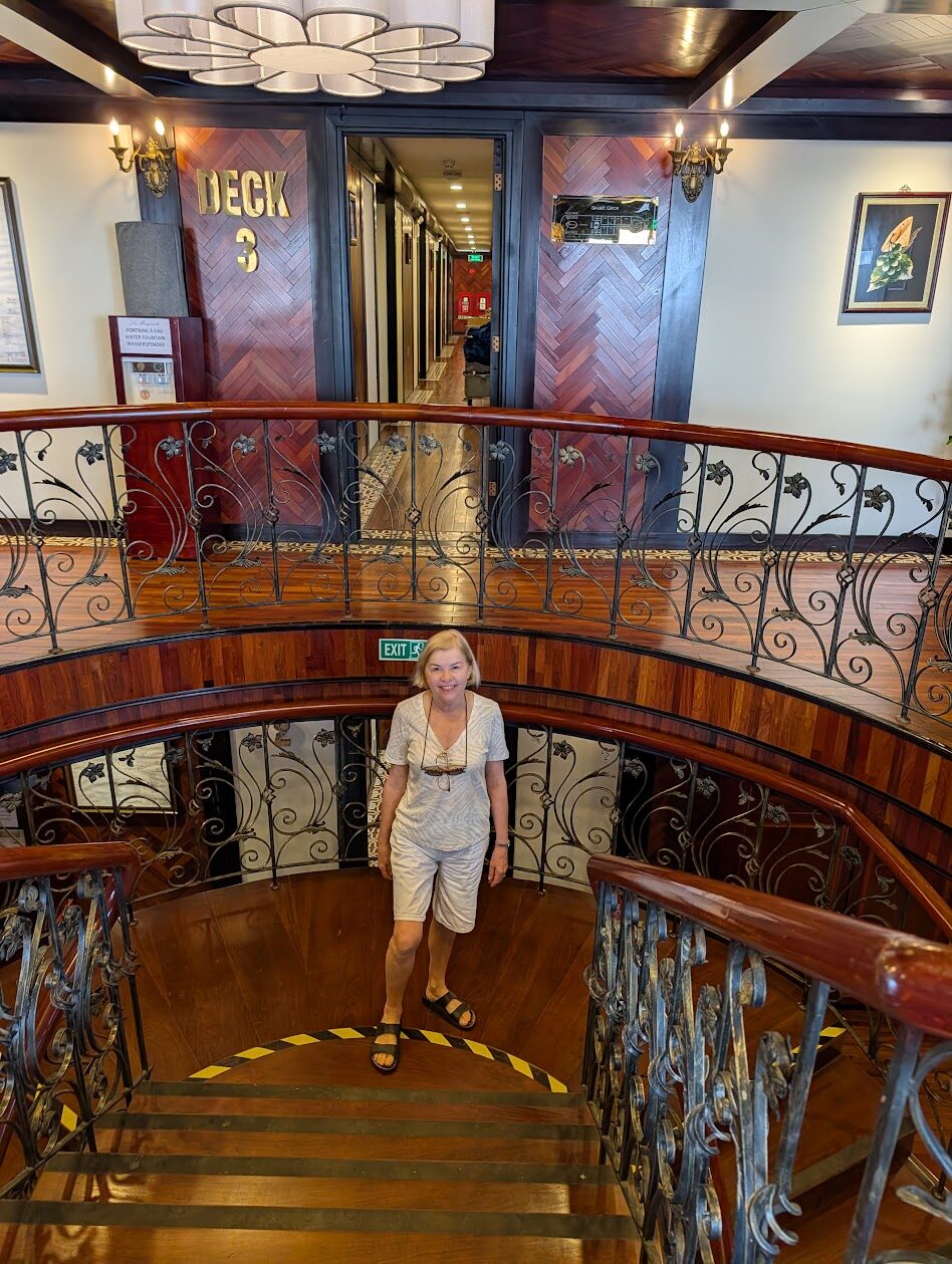 Spiral staircase with wrought-iron balustrade leading to Deck 3 on La Marguerite
